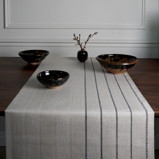 Near picture of the table runner Gardet in the color black/red, from Klassbol&#39;s linen fabric